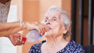 An elderly woman is given water (iStock image)