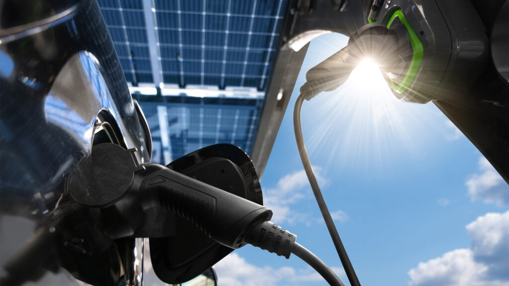 An electric vehicles is charged from a charging station that gets energy from solar panels. (iStock image)