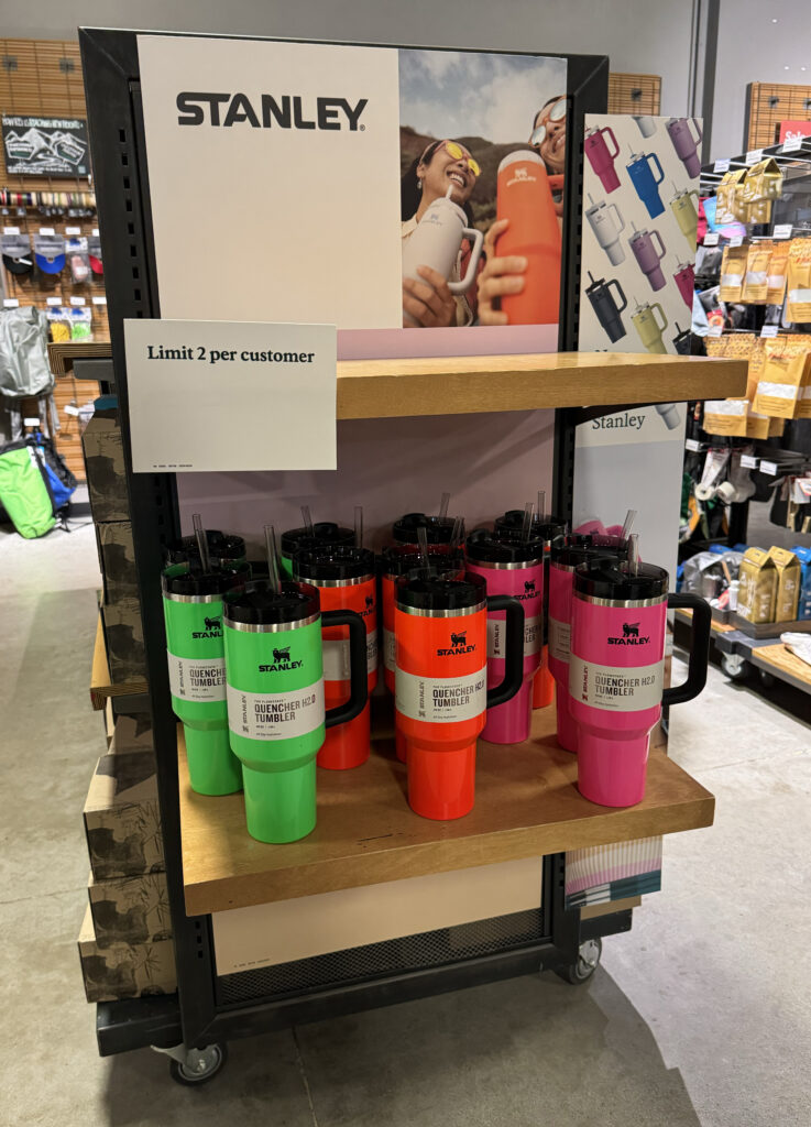 A display featuring reusable Stanley brand cups for sale, with a limit of two per customer, at a sporting goods store. (PK-WIKI, CC BY 4.0, via Wikimedia Commons