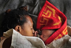 A woman sleeps with her baby in the maternity ward of a hospital in Goroka in the Eastern Highlands Province of Papua New Guinea in 2009. (Jason South/Fairfax Media/Getty Images via Grist)