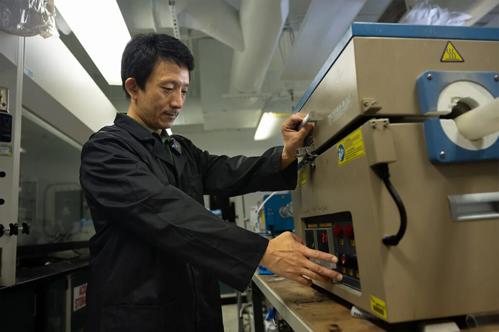 Yang Yang, an associate professor in UCF’s NanoScience Technology Center, works with a device that helped develop his triple-phase device that captures and converts carbon dioxide. (Photo by Antoine Hart)