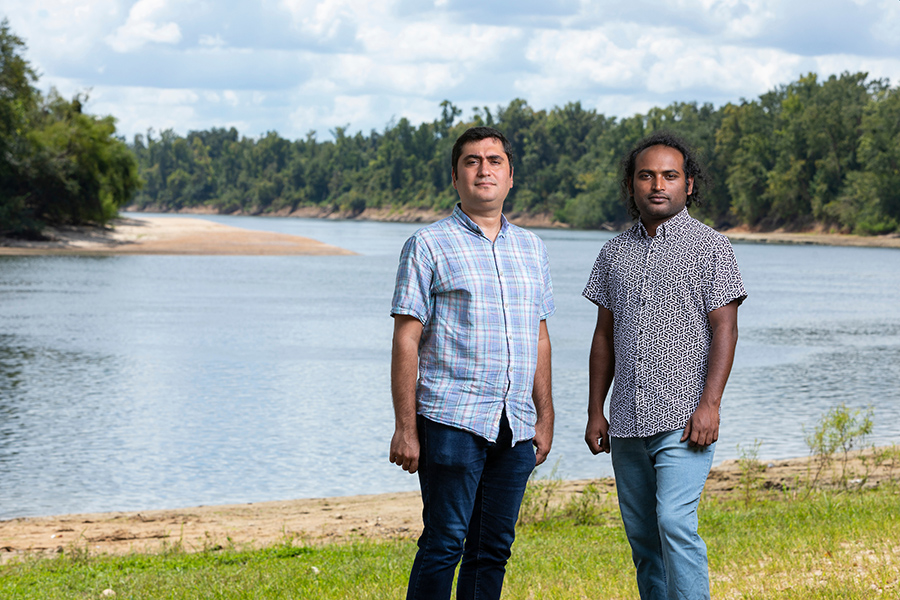 From left, Ebrahim Ahmadisharaf, assistant research professor in the Department of Civil and Environmental Engineering and the Resilient Infrastructure & Disaster Response Center at FAMU-FSU College of Engineering, and doctoral student Sumon Hossain Rabby on the bank of the Apalachicola River at Ocheesee Landing. (Scott Holstein/FAMU-FSU College of Engineering)