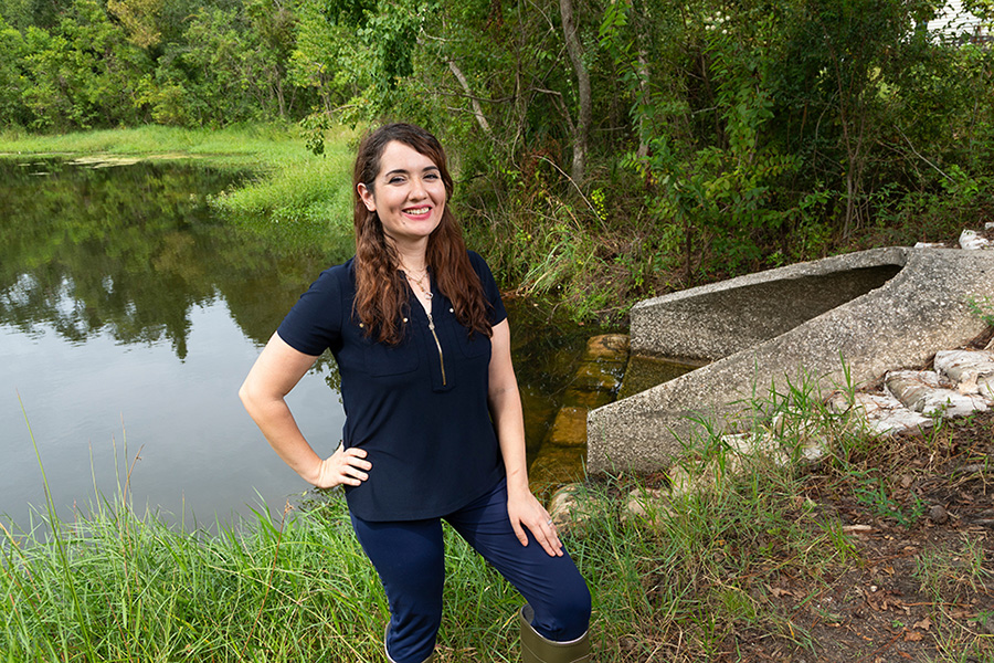 Nasrin Alamdari, assistant professor of Civil and Environmental Engineering at FAMU-FSU College of Engineering, poses by a stormwater culvert at Central Pond in Innovation Park in Tallahassee on Sept. 10. Alamdari is studying the transport of microplastics from urban environments to water resources via stormwater runoff. (Scott Holstein/FAMU-FSU College of Engineering)