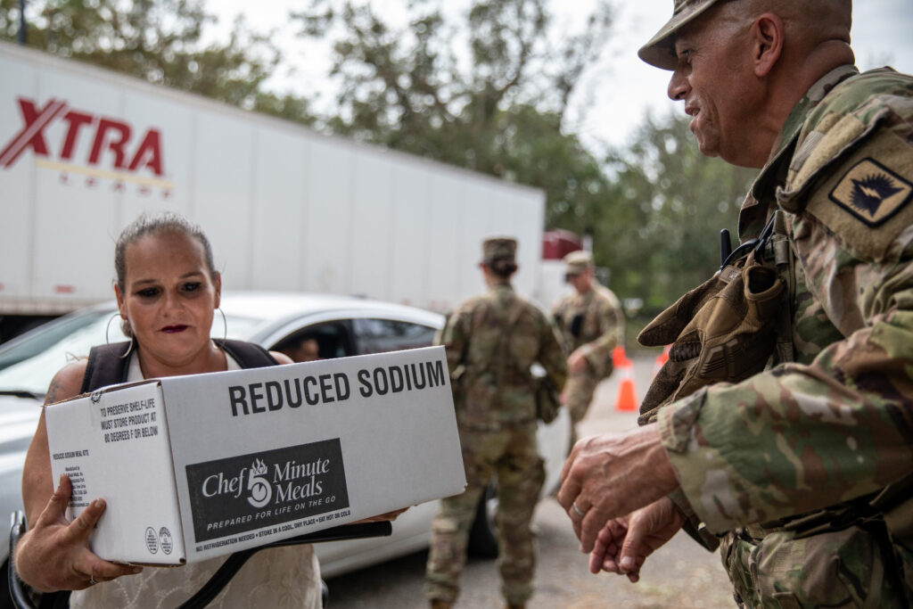 Florida Army National Guard Staff Sgt. Martin Martinez distributes food in Bradenton to assist the local community Oct. 11 following Hurricane Milton Oct. 11. (U.S. Army photo by Sgt. Marc Morgenstern, via Defense Visual Information Distribution Service)